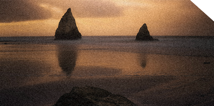 Light of Life 3 A large stone and small stone sit in the ocean gently illuminted by the sunset.